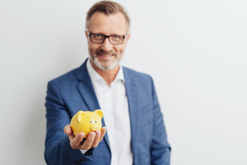 Smart businessman holding a piggy bank