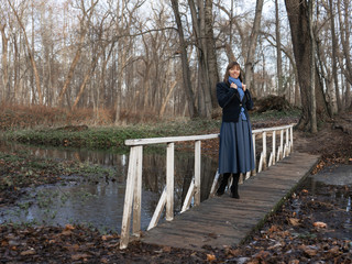 Fototapeta premium A young woman walks around an old manor, a castle, a beautiful park. Tourism, sightseeing. Traveling in Belarus. The surroundings of Minsk.