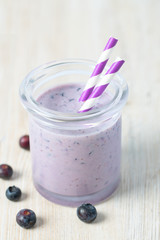 blueberry smoothie in a glass on wooden surface