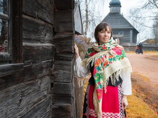 A young woman in a Russian or Belarusian national costume. Photography historical reconstruction. National traditions of the Russian village and its life. Autumn.