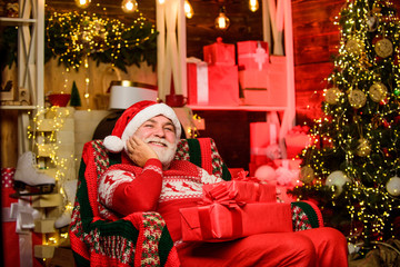 Obraz na płótnie Canvas Santa Claus relaxing in arm chair. Bearded senior man Santa Claus. Traditions concept. Elderly grandpa at home. Legend about Santa Claus. Merry christmas. Delivering gifts. Presents for family