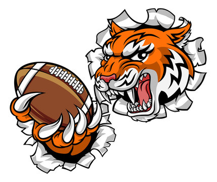 A tiger American Football player cartoon animal sports mascot holding a ball in its claw