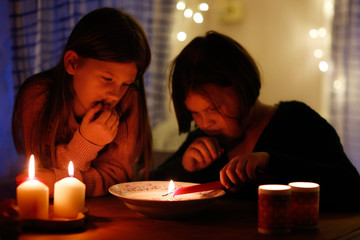 Magic two children guess with candles in the dark
