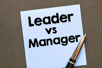 Leader vs Manager text on small sheet and wooden background. High resolution photo - business...