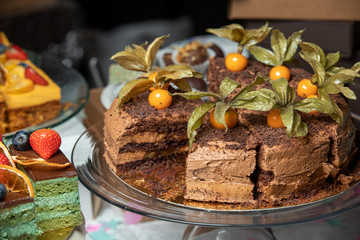 Sliced tasty chocolate cake in plate on table, closeup