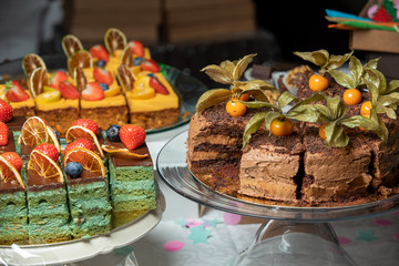 Sliced tasty chocolate cake in plate on table, closeup