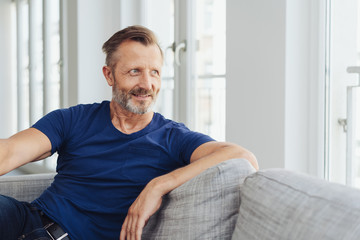 Attractive middle-aged man relaxing at home - obrazy, fototapety, plakaty