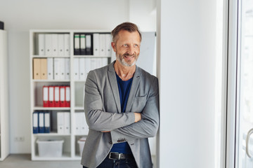 Businessman standing watching with amused smile