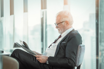 Senior man business professional in suit sitting in lounge of hotel. Man modern executive successful , lifestyle business handsome portrait. Success concept