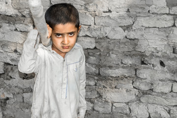 a very young orphan child is forced into child labor and working at a construction site and his...