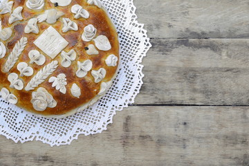 Homemade decorated Serbian slava bread on the rustic wooden board.