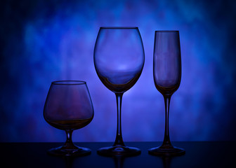 Silhouettes of wine glasses. Beautiful glass goblets. Collection of beautiful glasses on a blue background.