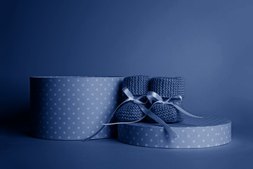 Blue gift box and small blue booties for a newborn.