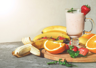 banana, strawberry and orange smoothies with mint on the table, front view - 307581521