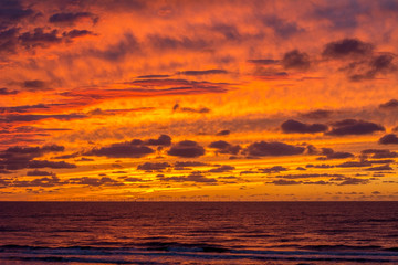 Obraz premium Beautiful yellow and orange sundown with many clouds over the sea in Europe in the summer