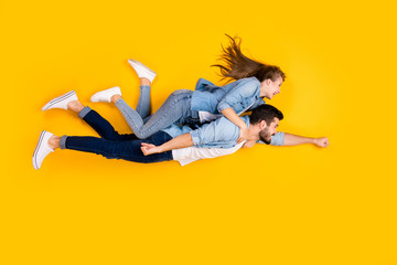 Top view above high angle flat lay flatlay lie full length body size view concept of cheerful beautiful handsome spouses flying embracing isolated on bright vivid shine vibrant yellow color background