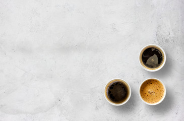 paper cups of coffee on cement table background. top view