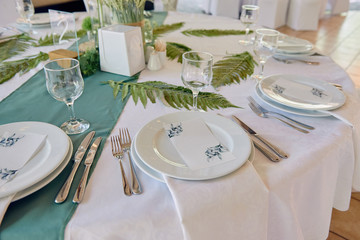 Table setting with sparkling wineglasses and cutlery on table, copy space. Menu mockup, place setting at wedding reception. Table served for wedding banquet in restaurant