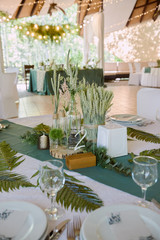 Beautiful floral arrangement in glass vase on wedding table in restaurant, copy space. Luxury wedding decorations. Table setting