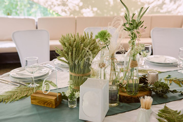 Beautiful floral arrangement in glass vase on wedding table in restaurant, copy space. Luxury...