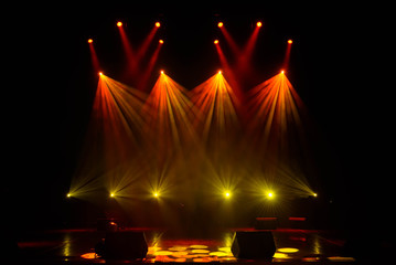 Lights beams on stage with musical instruments