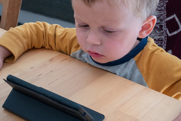 Portrait of toddler boy playing with a smartphone