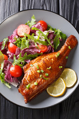 Fried Sebastes served with fresh vegetable salad close-up in a plate. Vertical top view