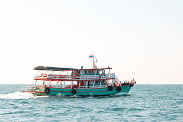 A boat brings tourists to an island in the sea in Thailand.