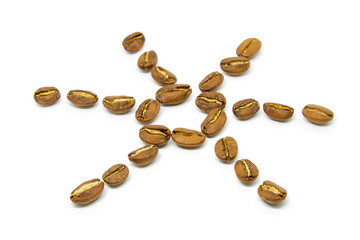 Coffee beans arranged in the form of the sun on a white background close-up.