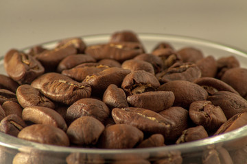 Close-up on top of a wine glass filled to the top with coffee beans. Selective focus.