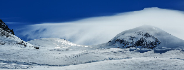 White winter mountains covered with snow in blue cloudy sky. Alps. Austria.