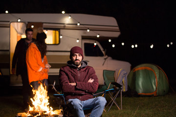 Portrait of bearded tourist with hand crossed in front of camp fire