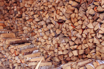 Firewood is stacked in winter. Chopped pile of wood. Lots of wood. Preparation of firewood for the winter Winter background texture pattern with stacked dry chopped firewood