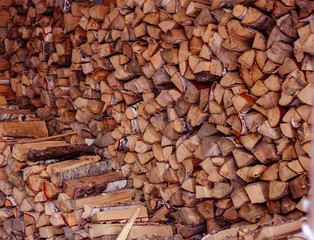Firewood is stacked in winter. Chopped pile of wood. Lots of wood. Preparation of firewood for the winter Winter background texture pattern with stacked dry chopped firewood