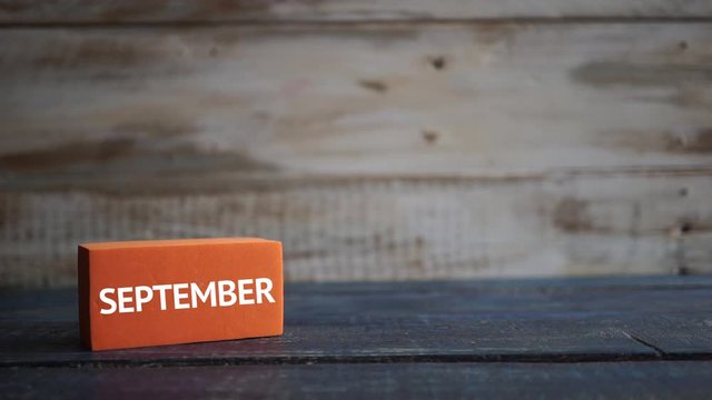 september 11th. Day 11 of month, calendar on a color cubes. hand puts the day of the month on the name of the month on a wooden background autumn, day of the year concept