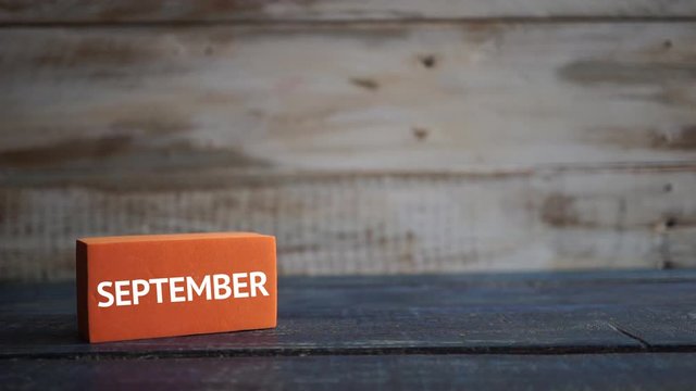 september 14th. Day 14 of month, calendar on a color cubes. hand puts the day of the month on the name of the month on a wooden background autumn, day of the year concept