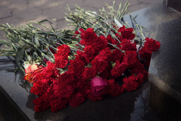 carnation flowers laid on the granite monument