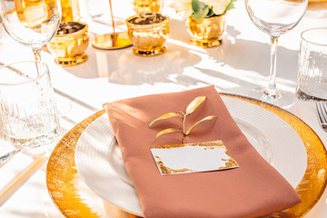 Wedding table setting with a nameplate in gold color