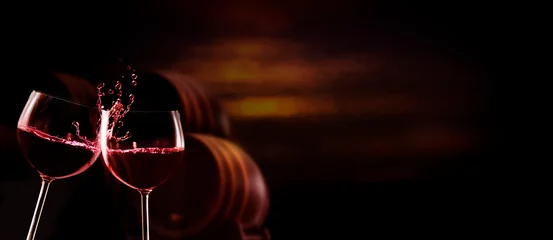 Küchenrückwand glas motiv Glasses with red wine toast, in the dark background are wine barrels © fotoknips