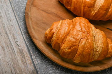 croissant closeup. Fresh french croissant. To on a wooden background. View from above. Morning breakfast with a croissant. French breakfast