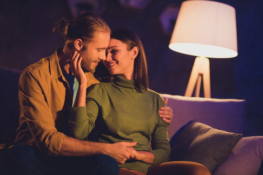 Close-up portrait of his he her she nice attractive lovely affectionate tender lovable cheerful dreamy couple girl sitting on divan spending day weekend kissing at night dark home house apartment