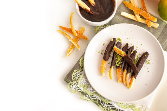 Candied orange peel in chocolate or sugar is a favorite Christmas treat for children and adults. Image of home made candied orange peel some pieces dipped in chocolate. Top view
