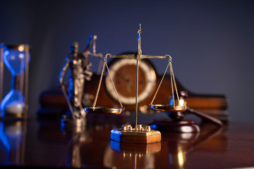 Law concept. Judge’s gavel, scale and old clock on dark background.