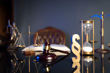 Law concept. Judge’s gavel, paragrahp sign and scale on dark background.