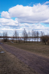 nature picture in early spring by the lake with trees and cloudy sky