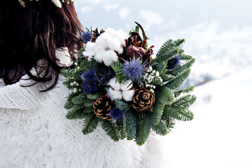 Winter bouquet of the bride. Fir branches, cotton flowers in a bride's bouquet