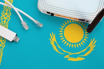Kazakhstan flag depicted on table with internet rj45 cable, wireless usb wifi adapter and router....