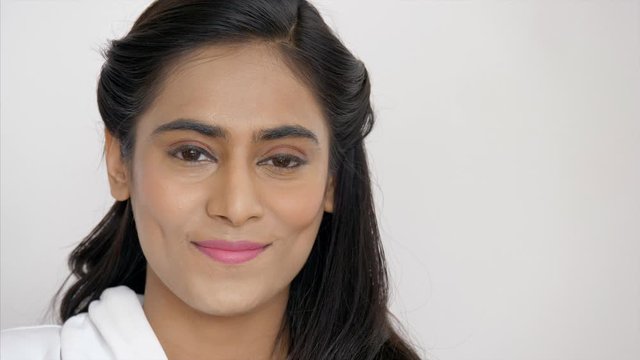 Free Video of Beautiful Indian woman smiling wearing subtle makeup and simple hairstyle . HD Stock Video of a young Indian pretty looking woman with a white backdrop/ background
