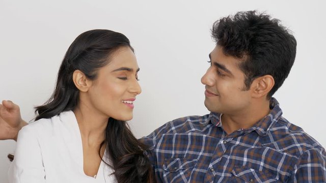Young Indian couple in love sitting together and chit chatting. 4K Stock Footage of Indian man showing affection to his lover - Boy and Girl in Relationship 