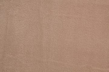 Fototapeta premium Fabric fleece beige view from the top. Texture of textile fleece bedspread.